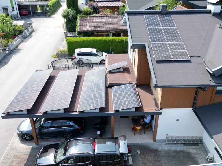 Dach mit Photovoltaikanlage und Carport in Saalfelden, ebenerdige Parkplätze.