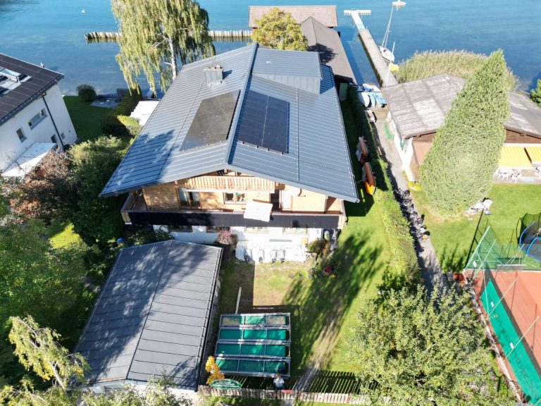 PV-Anlage auf einem modernen Wohnhaus in Zell am See, Umgebung mit Garten und Tennisplatz.