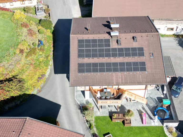 Dach mit 35 kWp PV-Anlage in Bruck an der Großglocknerstraße, Garten und Wohnbereich sichtbar.